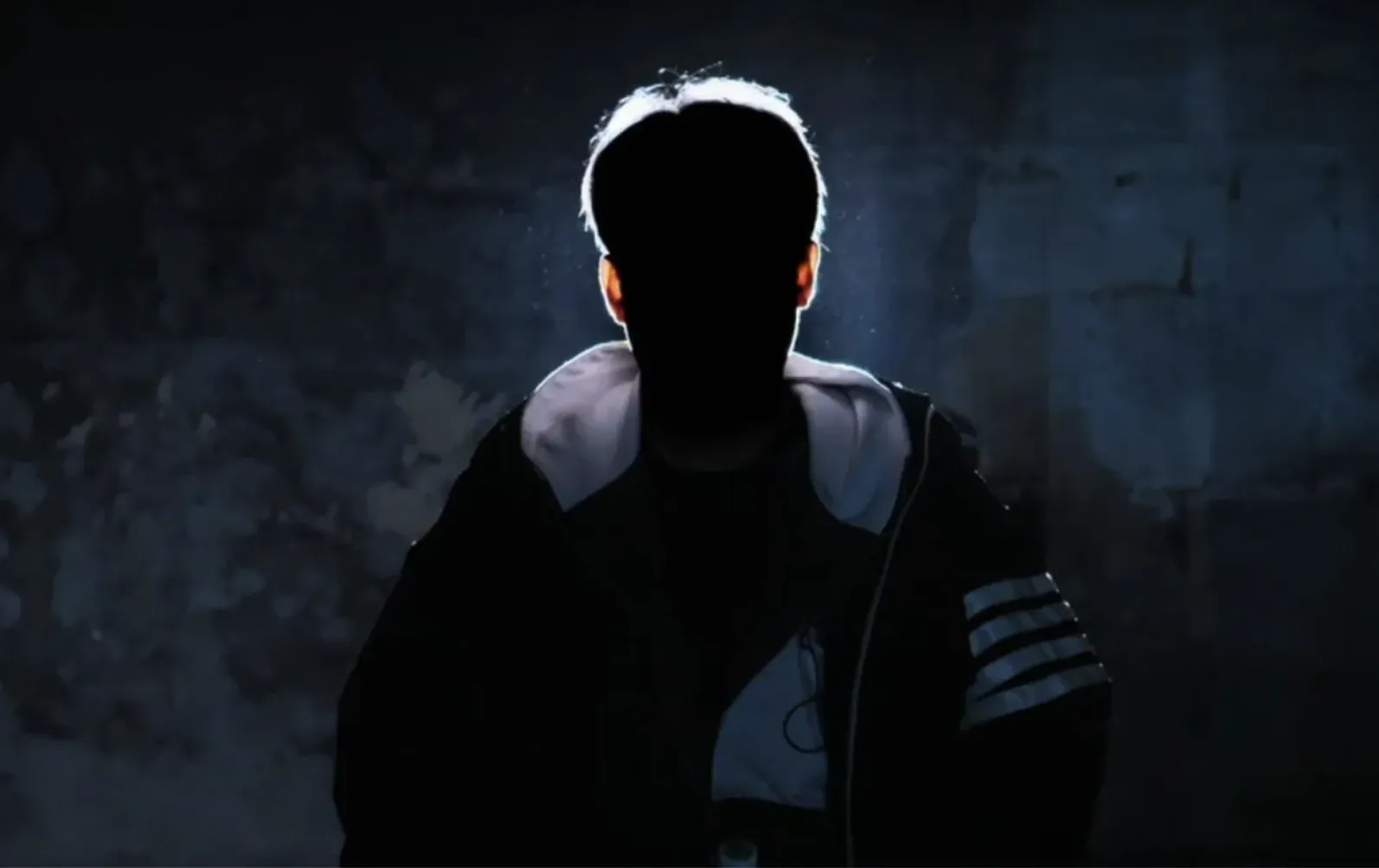 A man in silhouette against a dark blue background, a still from the BBC documentary Burning Sun.